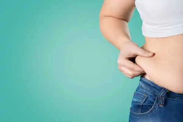 Image of woman pinching her love handles to show weight gain Pinner